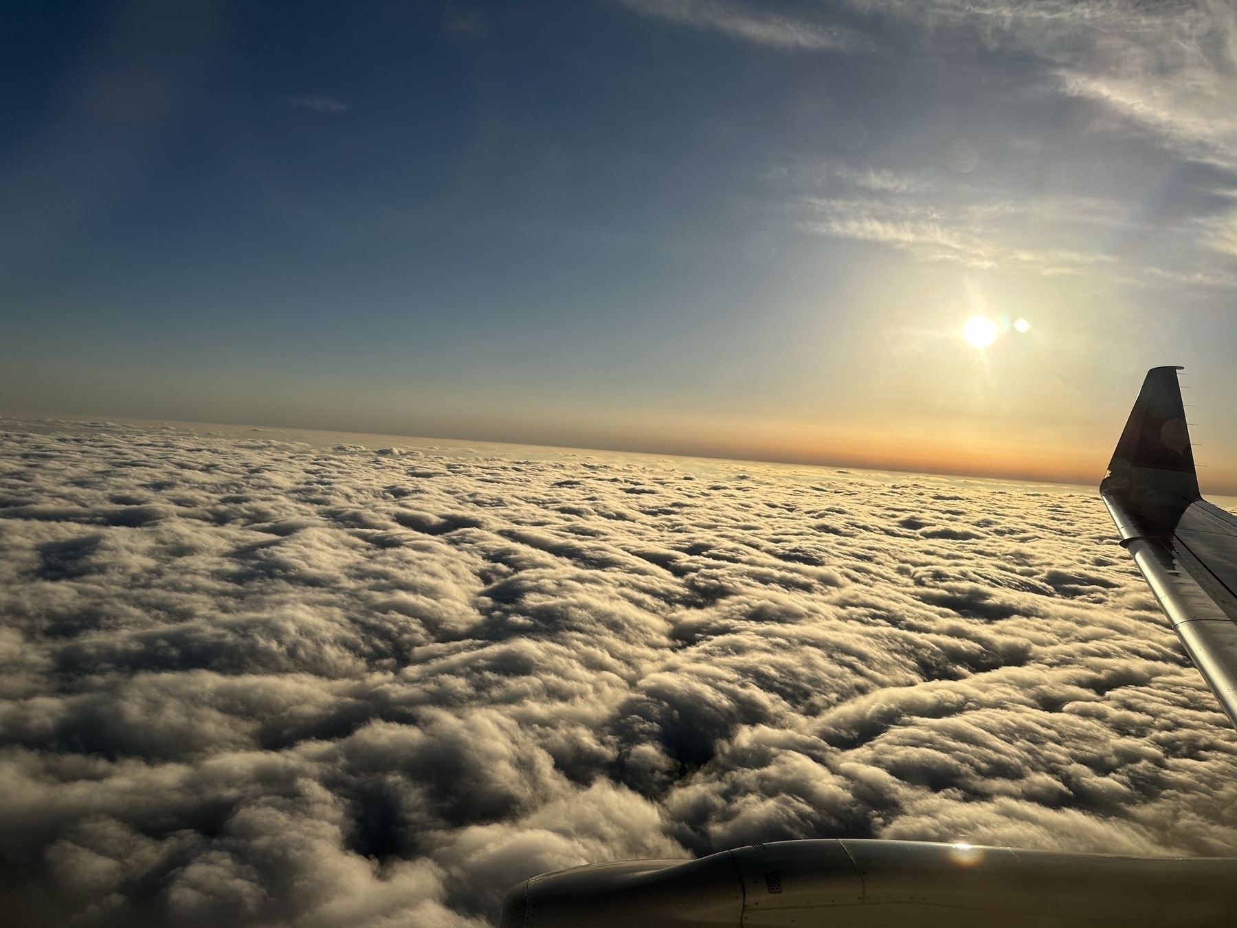 Just above the clouds in a tiny plane.